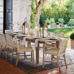 an outdoor dining table with chairs and place settings