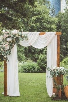 an outdoor ceremony with white drapes and flowers