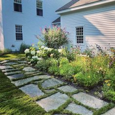 a stone path in front of a white house