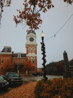 an old building with a clock tower in the middle of it's front yard