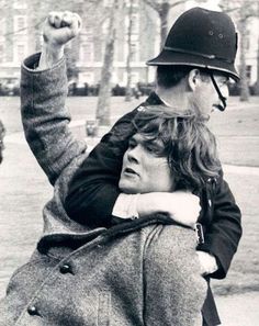 a man riding on the back of a woman who is wearing a helmet and jacket