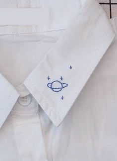 a white dress shirt with an embroidered space motif