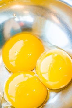 three fried eggs in a silver bowl