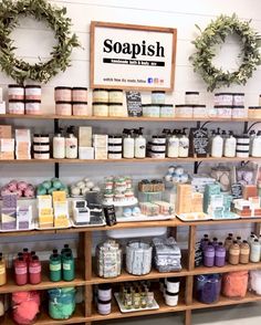 the shelves are filled with soaps, candles and other items in front of a sign that says soapish