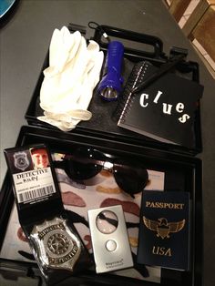 an open suitcase with passport, sunglasses and other items on it sitting on a table