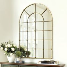 a dresser with a mirror and vase on top