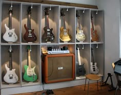 guitars are lined up on shelves in a room