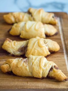 several pastries are on a wooden cutting board