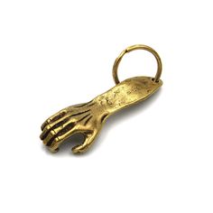 a gold keychain shaped like a hand