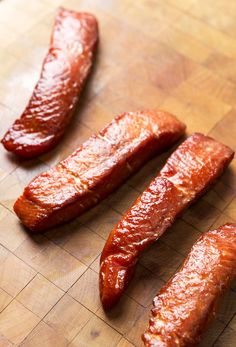 three sausages are on a cutting board ready to be cooked