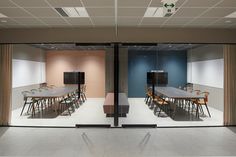 an empty conference room with tables and chairs in front of the glass doors that are open