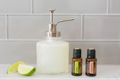 a soap dispenser, lime and essential oils sit on a countertop