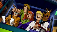 scooby and friends driving in a car with the driver pointing at something on the screen