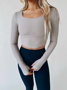 DETAILS: Our Cropped Long Sleeved Athletic Top has a soft to the touch fabric that has a good stretch in it for comfort. This long sleeved item has a square neckline that is very flattering. On this item you will see what looks to be a raised seam but it is actually a thin elastic band that gives it a cool detail on the top. On the sleeves it has as cut-out for your tumbs. This is a MUST HAVE in your closet for when you want to have a cute sporty day! CONTENT & CARE: SELF: 75% Nylon, 25% Spandex Best Stretches, Custom Jacket, Athletic Top, Good Stretches, Pop Up Shop, Square Necklines, Square Neckline, Two Pieces, Elastic Band