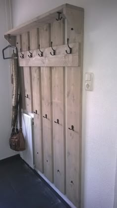 the coat rack is made out of wood and has hooks for coats on each side