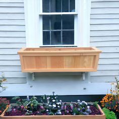 a window sill filled with flowers in front of a house