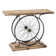 an old bicycle wheel is sitting on top of a wooden table with wheels attached to it