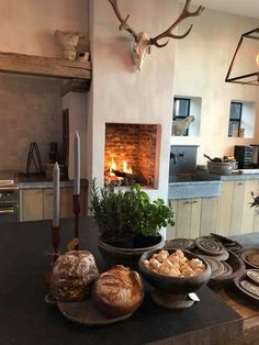 a kitchen counter topped with plates and bowls filled with food next to a fire place