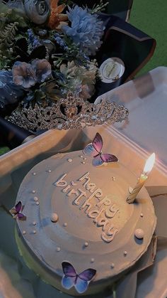 a birthday cake sitting on top of a table with a lit candle in the middle