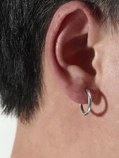 a close up view of a person's ear with a pair of hoop earrings on it