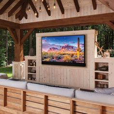 a large screen television mounted to the side of a wooden wall in a living room