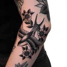 a person with a bird and flowers tattoo on their arm