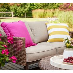 a couch sitting on top of a wooden floor next to a table filled with flowers