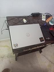 a laptop computer sitting on top of a wooden table