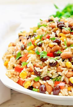 a white bowl filled with rice, beans and veggies on top of a table