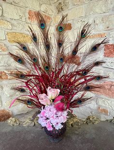 a vase filled with flowers and peacock feathers