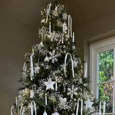 a christmas tree decorated with white and silver ornaments