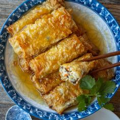 some food is on a blue and white plate with chopsticks next to it