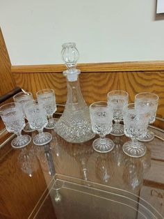 an assortment of wine glasses sitting on top of a glass table