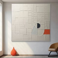 an abstract painting hangs on the wall next to a chair and vase in a white room