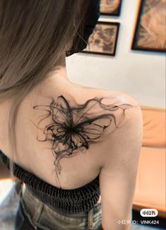 a woman with a butterfly tattoo on her back shoulder