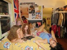 several young women laying on a bed in a bedroom