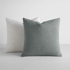 two pillows sitting next to each other on a table