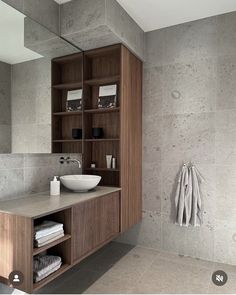 a bathroom with a sink, mirror and towel rack in it's center area