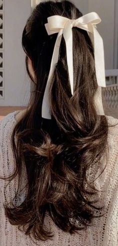 the back of a woman's head wearing a white bow