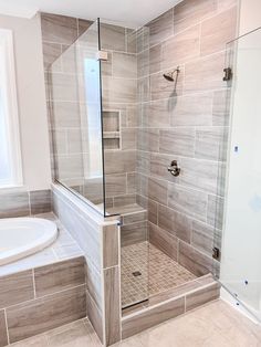 a walk in shower sitting next to a bath tub