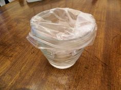 a plastic cup sitting on top of a wooden table