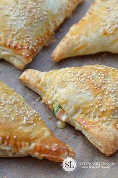 several pastries with sesame seeds and peas are on a piece of parchmented paper