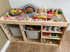 a child's play table with toys and storage bins