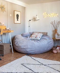 a large bean bag chair sitting on top of a wooden floor next to a table