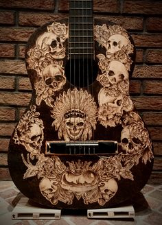 a guitar with skulls on it sitting in front of a brick wall