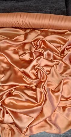 1mtr  bright peach colour smooth silky elegant  liquid satin fabric. This is really lovely smooth silky elegant chameuse fabric . Great to make wedding wear dresses crafts  draping Price for a mtr . all fabrics bought more than a mtr are always one continues length thanks. due to lighting colour may be slightly different shade .more than a mtr all fabrics in my shop will be one continues length thank you. Wedding Satin Dress With Modal Satin Finish, Wedding Satin Dress With Satin Finish, Solid Color Silk Satin Dress, Pink Silk Satin Wedding Dress, Silk Fabric Swatch, Luxury Peach Organza Dress, Wedding Silk Fabric With Satin Finish, Peach Fabric Texture, Peach Brocade Fabric