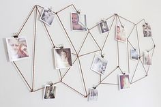 a group of pictures hanging on a wall next to a string with photos attached to it