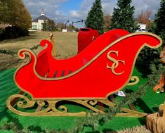 a large red sleigh sitting on top of a lush green field