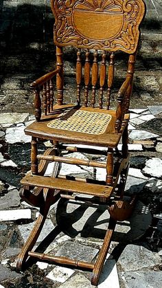 a wooden rocking chair sitting on top of a stone floor