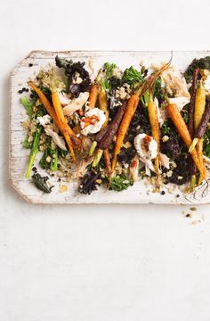 carrots, broccoli, and other vegetables on a white platter with crumbs